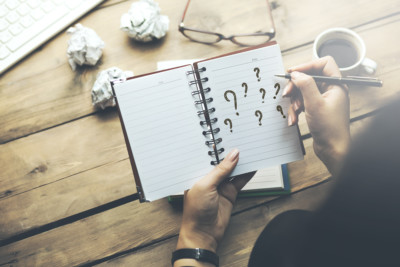 woman written question mark on notepad